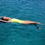 Model laying in the water at the photoshoot for the cover of Living Barbados