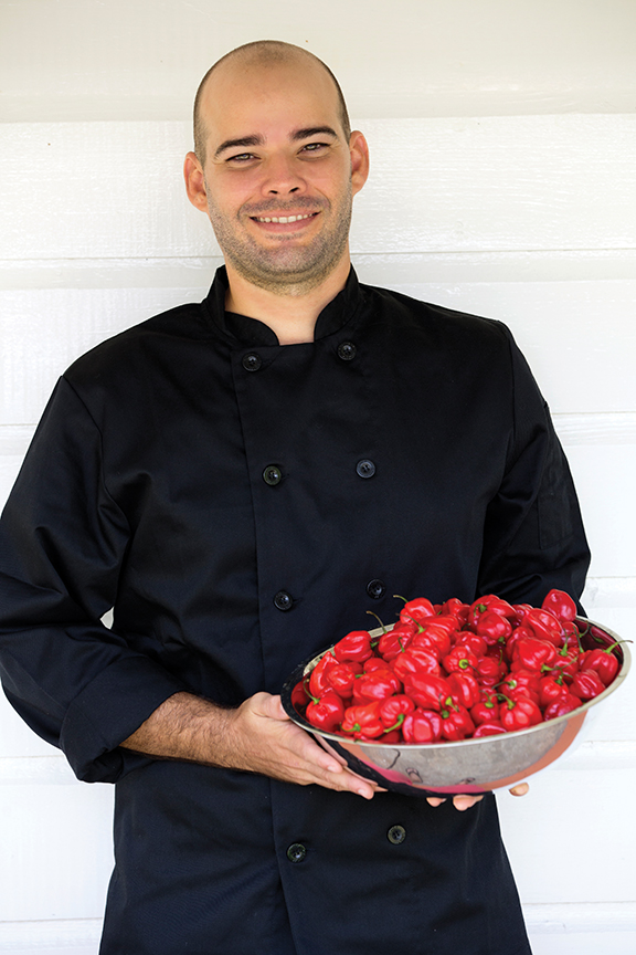 Man holding bowl of hot peppers